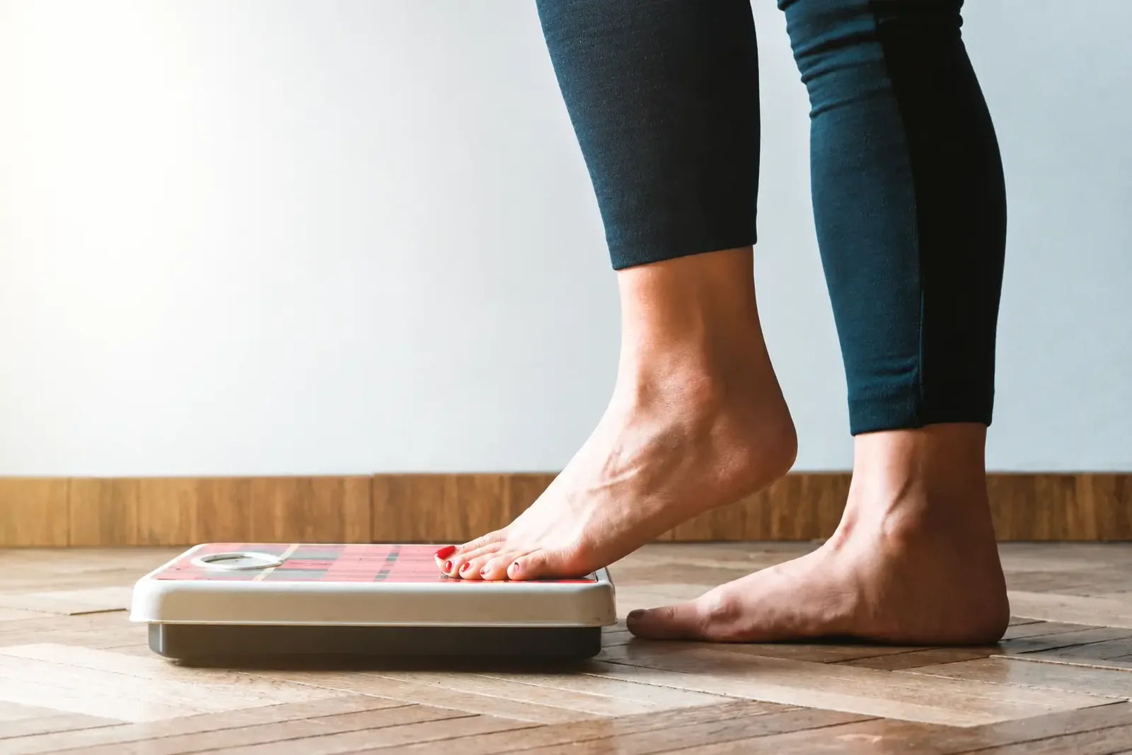Person stepping onto a bathroom scale